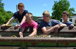Students check temperature of compost and carbon in manure spreader