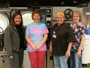 Becca Bittner (left) and her staff take a break from preparing lunch for students to pose for a photo.