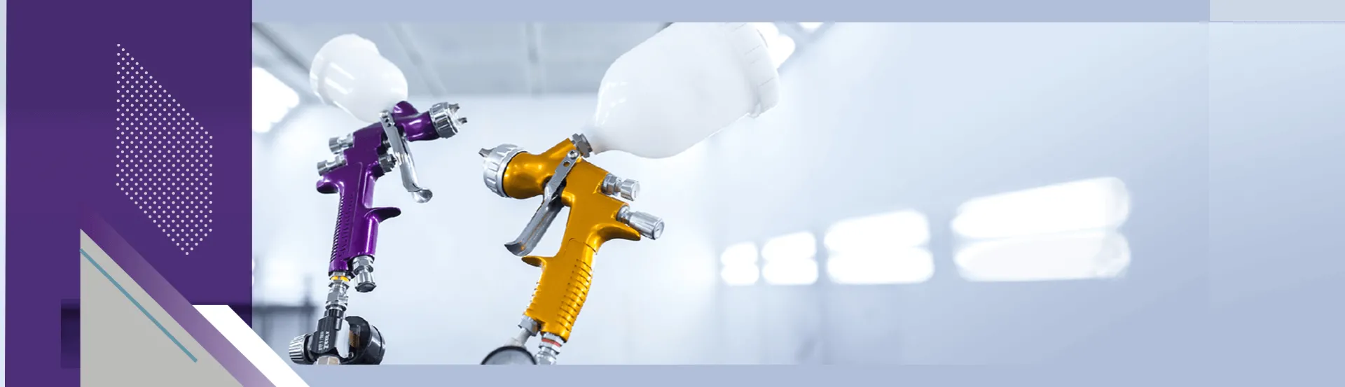 Two gravity feed paint guns used for painting vehicles shown inside spray booth