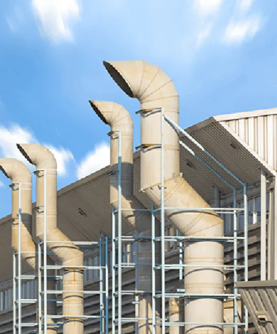 Ventilation shafts outside local business against blue sky.